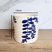 Load image into Gallery viewer, The Leaferie Hamsa blue petals on white ceramic pot.