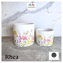 Load image into Gallery viewer, The Leaferie Rhea Two ceramic planters with floral designs on a marble surface, featuring the brand 'LEAFERIE'.