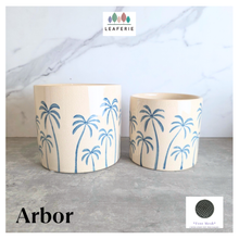 Load image into Gallery viewer, Arbor planters with palm tree design on a marble surface, featuring the Leaferie brand.