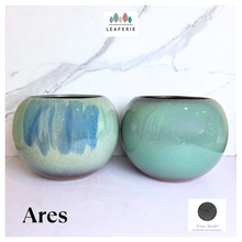 Load image into Gallery viewer, Ares Two green ceramic pots on a white marble surface with 'LEAFAERIE' branding.