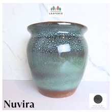 Load image into Gallery viewer, Leaferie Nuvira ceramic planter pot with a glossy green and brown speckled glaze, shown against a white marble background with brand and color swatch overlays.