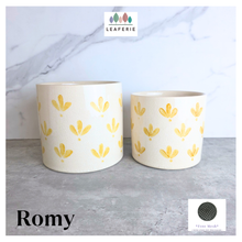 Load image into Gallery viewer, Romy Two ceramic planters with yellow patterns on a gray surface, branded 'LEAFERIE'.