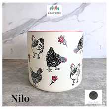 Load image into Gallery viewer, Nilo Ceramic pot with chicken design on a marble background, featuring the brand 'LEAFERIE'.