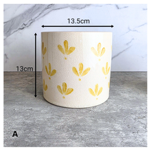 Load image into Gallery viewer, Romy Two ceramic planters with yellow patterns on a gray surface, branded 'LEAFERIE'.