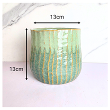 Load image into Gallery viewer, Pistachio Leaferie Green ceramic planter with gold accents on a white background, featuring the Leaferie brand