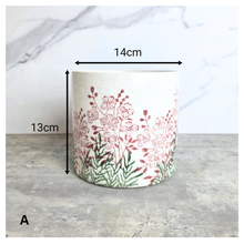 Load image into Gallery viewer, Lumelle Ceramic planter with floral design on a gray surface, featuring the brand 'LEAVERIE'.
