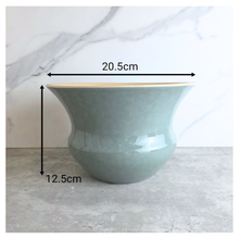 Load image into Gallery viewer, Soren Green ceramic vase with gold rim on a light gray surface, branded 'LEAFERIE'.