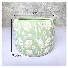 Load image into Gallery viewer, Coralie Green ceramic planter with white floral patterns on a gray background, featuring the brand 'LEAFERIE'.