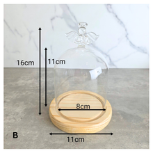 Load image into Gallery viewer, Angel Glass terrarium with a small plant on a wooden base, featuring the Leaferie brand.