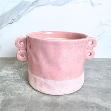 Load image into Gallery viewer, A pink speckled ceramic planter with two loop handles on the sides, shown on a gray stone surface against a white marble background. The brand name LEAFERIE is displayed at the top, and the color name 'Kova' along with a texture swatch graphic are shown in the corners.