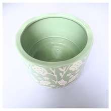 Load image into Gallery viewer, Coralie Green ceramic planter with white floral patterns on a gray background, featuring the brand 'LEAFERIE'.