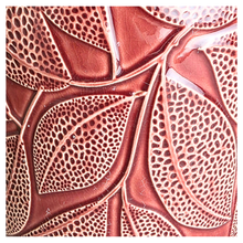 Load image into Gallery viewer, Talia Red ceramic planter with leaf pattern on a gray surface, branded 'LEAFERIE'.