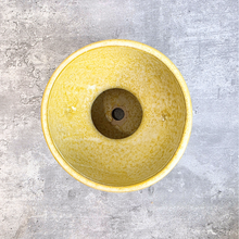 Load image into Gallery viewer, A top-down view of a round ceramic planter pot with a textured yellow glaze, set against a gray concrete background.
