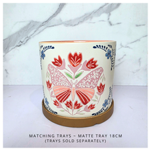 Load image into Gallery viewer, Bloomie Ceramic pot with floral and butterfly design on a marble background, featuring the brand 'LEAFERIE'.