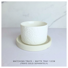 Load image into Gallery viewer, Orra White ceramic pot with textured design on a light gray background, featuring the brand 'LEAFERIE'.