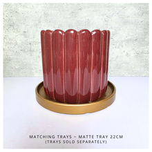 Load image into Gallery viewer, Rubi Red ceramic vase with ribbed texture on a light gray background, featuring the brand 'LEAFERIE'.