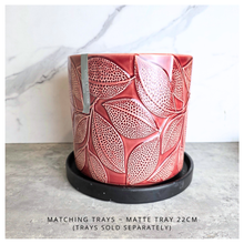 Load image into Gallery viewer, Talia Red ceramic planter with leaf pattern on a gray surface, branded 'LEAFERIE'.