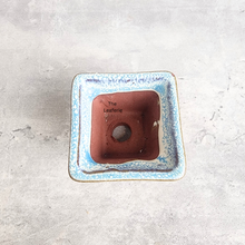 Load image into Gallery viewer, Small ceramic container with blue rim and brown interior on a light gray background
