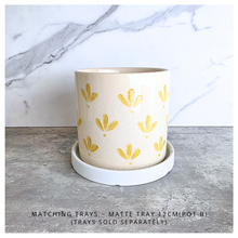 Load image into Gallery viewer, Romy Two ceramic planters with yellow patterns on a gray surface, branded 'LEAFERIE'.