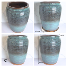 Load image into Gallery viewer, Avira by Leaperie, featuring a textured, ribbed glaze that transitions from a dark brown at the top to a vibrant teal-green at the base. The pot is shown from the front, side, and bottom angles against a white marble background.