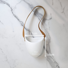 Load image into Gallery viewer, The Leaferie Patina hanging planter. material ceramic.white colour with leather strap. no drainage hole. front view and size