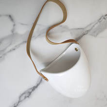 Load image into Gallery viewer, The Leaferie PAtina hanging planter. material ceramic.white colour with leather strap. no drainage hole. front view