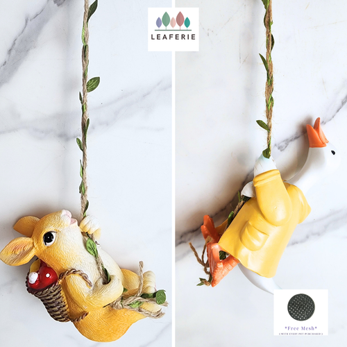 Pip Hanging Decoration .Two decorative items, a yellow mouse and a yellow duck, on a swing with 'LEAFERIE' branding.