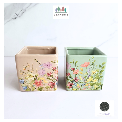 Two square flower pots with floral designs on a white background, branded 'LEAFERIE'.
