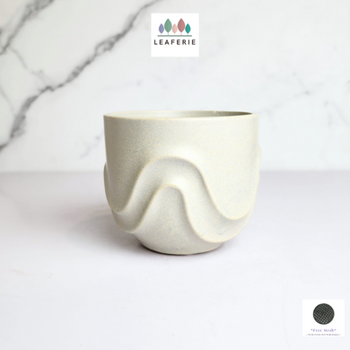 The Leaferie Tymo white pot. wavy design and ceramic material