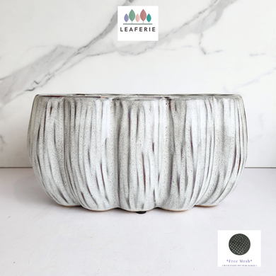 Textured ceramic planter on a marble background with Leaferie logo.