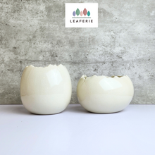 Load image into Gallery viewer, The Leaferie Maja Egg flowerpot. cream white ceramic pot. front view of designs
