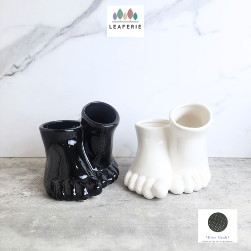The Leaferie Stomy foot black and white ceramic pot. 