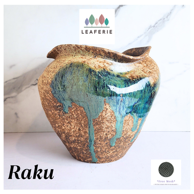 Raku ceramic vase with gold and blue glaze on a white background, featuring the Leaferie brand.