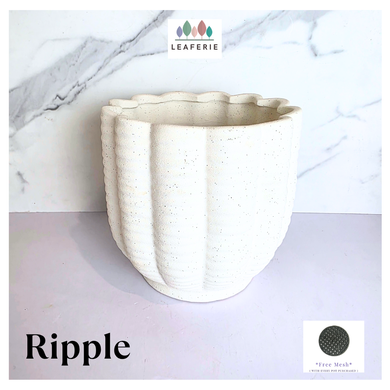 Ripple White ceramic planter with wavy texture on a marble background, featuring the Leaferie brand.