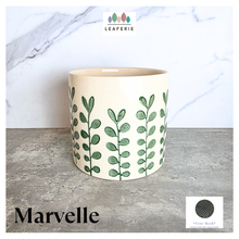 Load image into Gallery viewer, Marvelle Ceramic planter with green leaf pattern on a gray surface, branded 'LEAFAERIE'.
