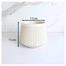 Load image into Gallery viewer, Oraya Leaferie White ribbed planter on a light gray background with Leaferie branding.
