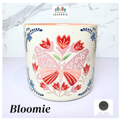 Bloomie Ceramic pot with floral and butterfly design on a marble background, featuring the brand 'LEAFERIE'.