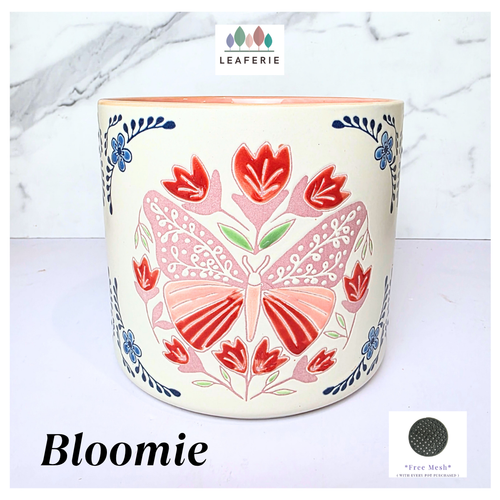Bloomie Ceramic pot with floral and butterfly design on a marble background, featuring the brand 'LEAFERIE'.