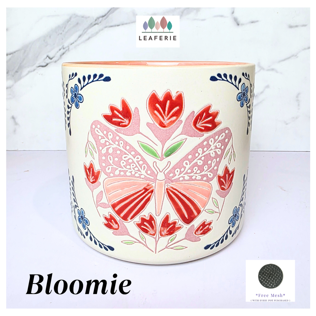 Bloomie Ceramic pot with floral and butterfly design on a marble background, featuring the brand 'LEAFERIE'.