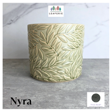Load image into Gallery viewer, Nyra Green ceramic planter with leaf pattern on a gray surface, featuring the Leaferie brand.
