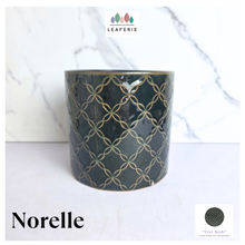 Load image into Gallery viewer, A dark green ceramic pot with a gold geometric trellis pattern, labeled 'Norelle' by the brand LEAFERIE, set against a white marble background.
