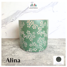 Load image into Gallery viewer, Alina pot Green plant pot with floral pattern on a wooden surface, branded 'LEAFAERIE'.
