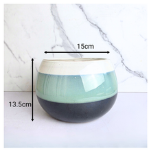 Load image into Gallery viewer, A glazed ceramic planter with a two-tone design, featuring a cream-colored top band, a light mint green middle band, and a dark charcoal gray bottom half. The image includes dimension overlays indicating a width of 15cm and a height of 13.
