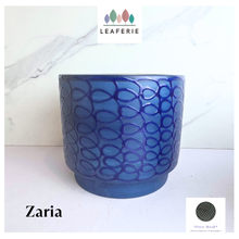 Load image into Gallery viewer, A cobalt blue ceramic planter with a textured, raised leaf-like pattern, labeled 'Zaria' by the brand LEAFERIE, set against a white marble background.
