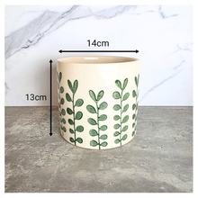 Load image into Gallery viewer, Marvelle Ceramic planter with green leaf pattern on a gray surface, branded 'LEAFAERIE'.

