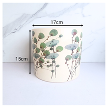 Load image into Gallery viewer, Cylindrical container with floral design and measurements on a marble background
