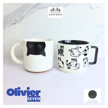 Load image into Gallery viewer, Two mugs with cat designs on a white surface, featuring the Leaferie and Olivier Seven logos.
