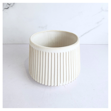 Load image into Gallery viewer, Oraya Leaferie White ribbed planter on a light gray background with Leaferie branding.
