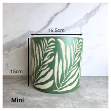 Load image into Gallery viewer, Lierre Green container with leaf pattern on a light gray surface, featuring the brand 'LEAFERIE'.

