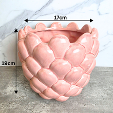 Load image into Gallery viewer, A pink ceramic planter with a textured, scaled leaf-like pattern, labeled 'Runa' by the brand LEAFERIE, set against a white marble background.
